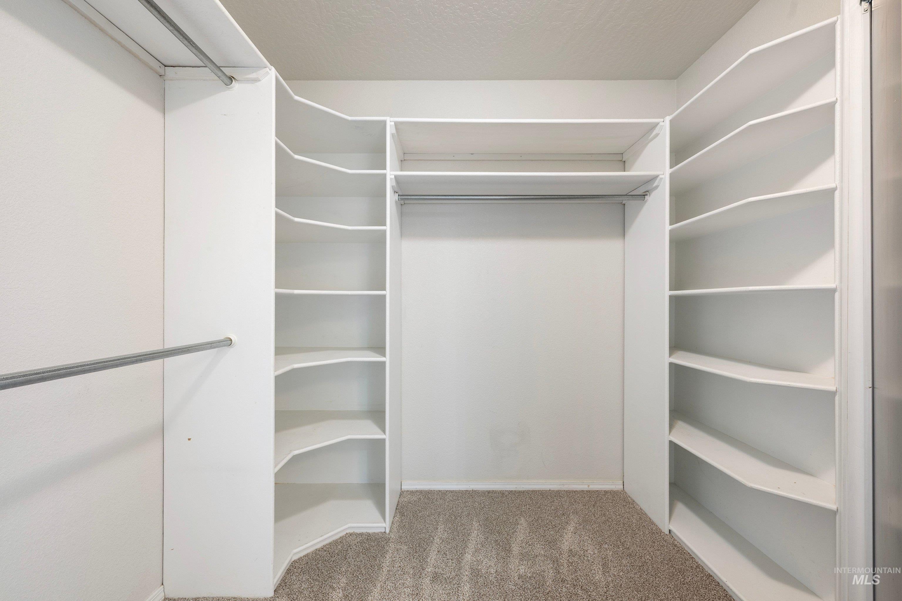 7657 Track Road Nampa, ID 83686 - Photo 24 of 49 Walk-in closet with carpet flooring, multiple hanging rods, and built-in shelving units
