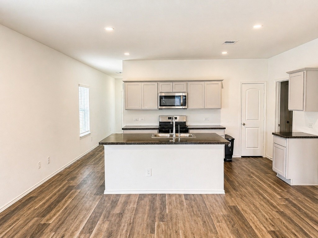 5218 Mossdale Blf Lane Spring, TX 77373 - Photo 6 of 14 a kitchen with stainless steel appliances a sink stove and cabinets
