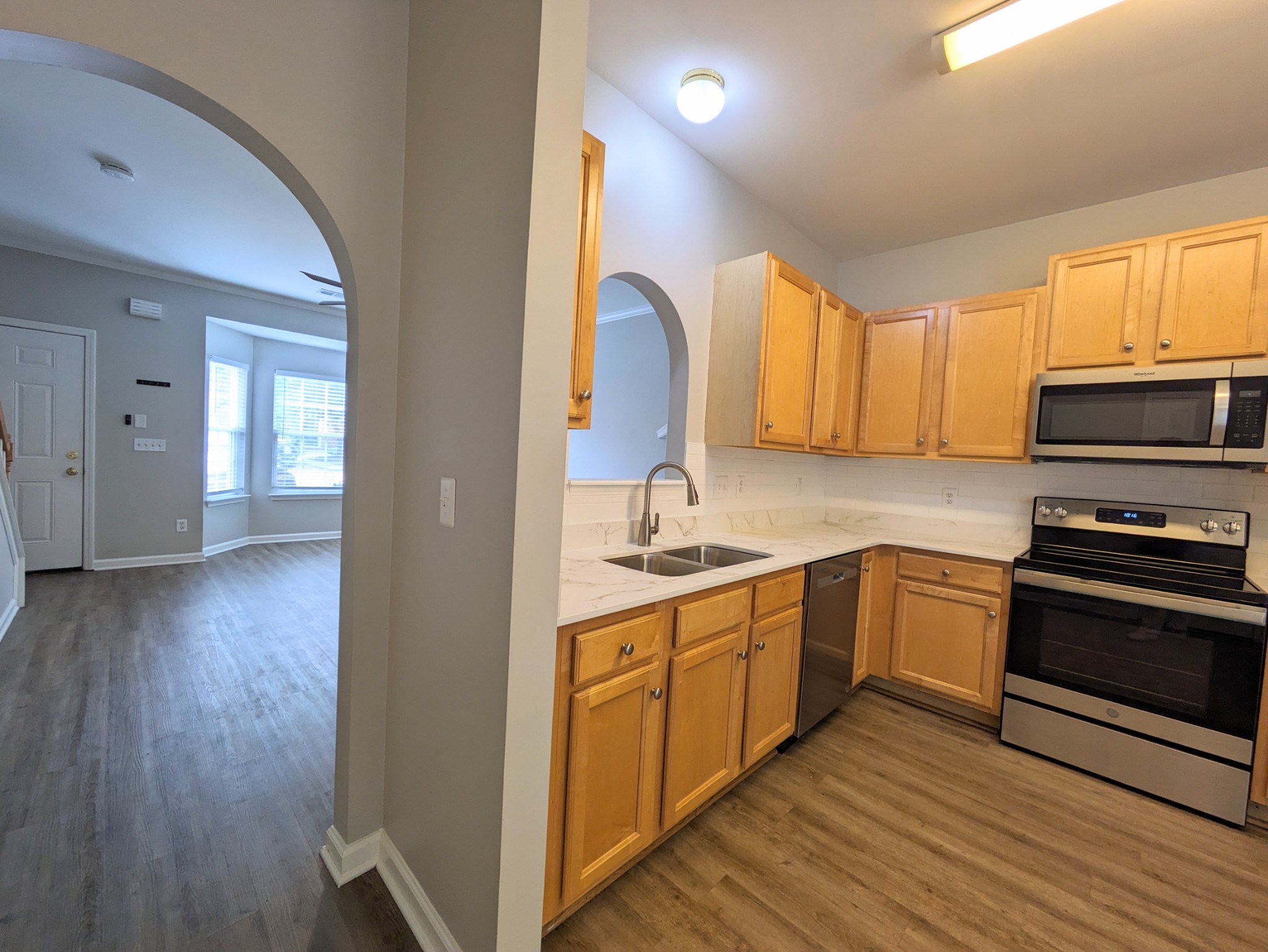 1101 Downs Boulevard, Unit B105 Franklin, TN 37064 - Photo 12 of 44 a kitchen with stainless steel appliances granite countertop a stove top oven a sink dishwasher and a microwave oven with wooden floor
