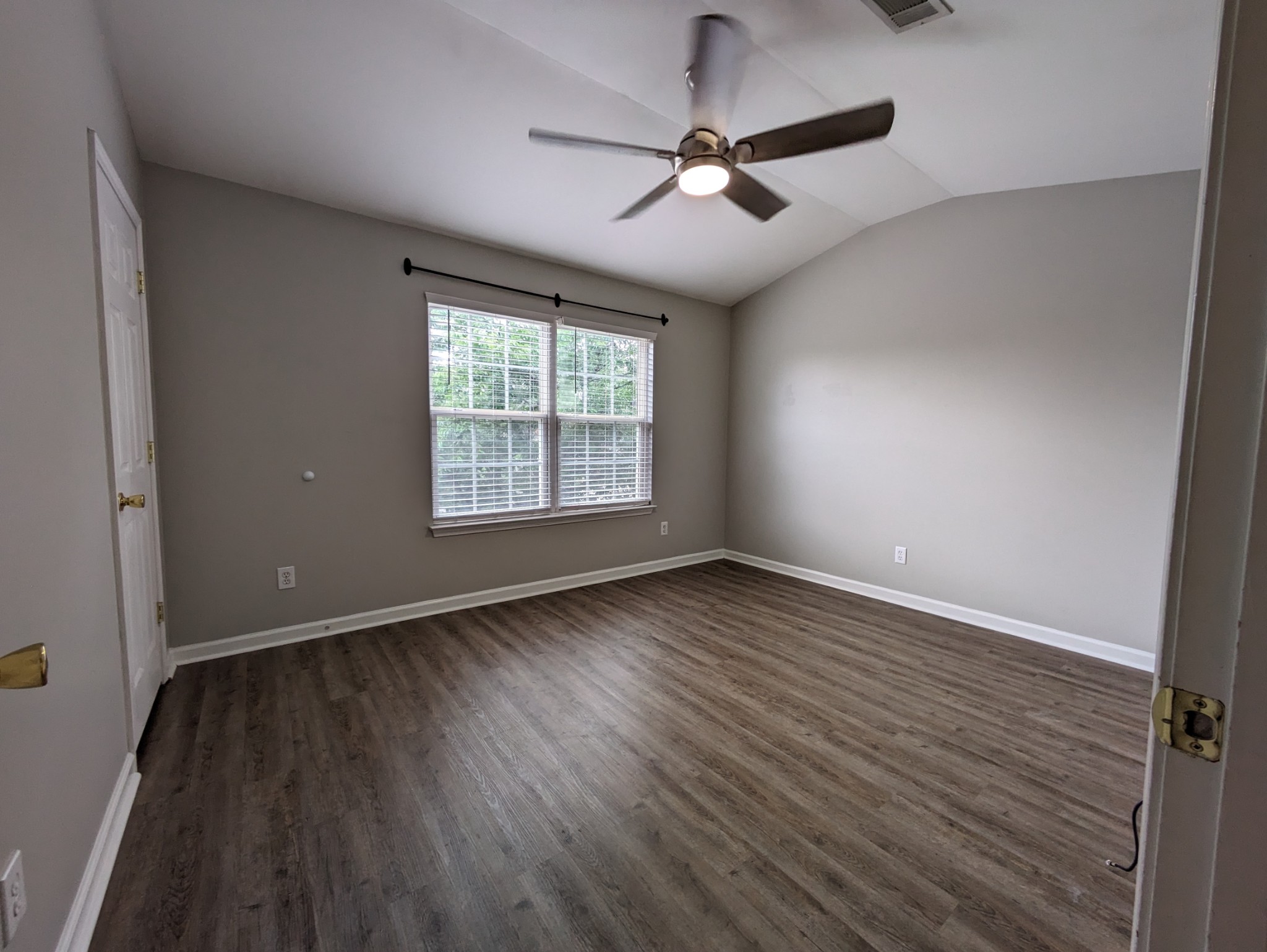 1101 Downs Boulevard, Unit B105 Franklin, TN 37064 - Photo 39 of 44 an empty room with wooden floor chandelier fan and windows
