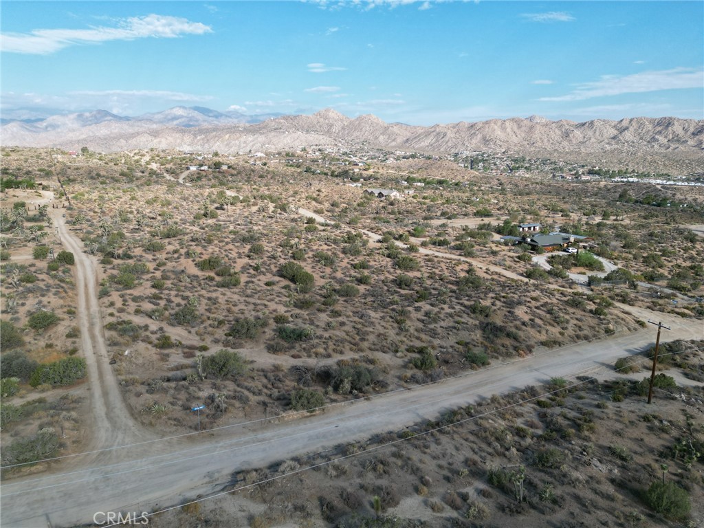 0 Kickapoo Trail Yucca Valley, CA 92284 - Photo 5 of 8 a view of a dry yard with mountains in the background