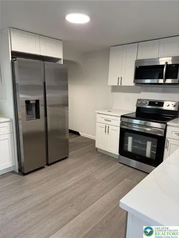 a kitchen with stainless steel appliances kitchen island granite countertop a stove a refrigerator and a microwave