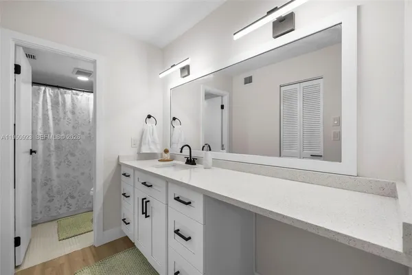 a bathroom with a double vanity sink mirror and shower