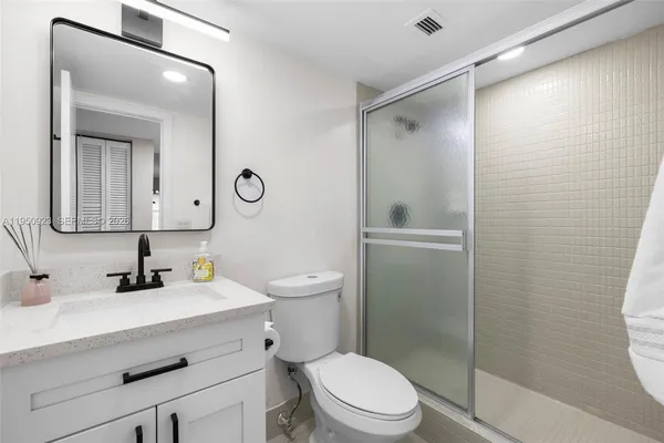 a bathroom with a toilet a sink and a mirror