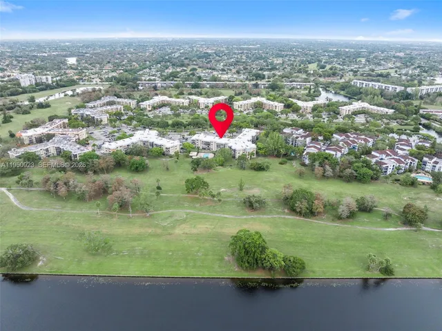 an aerial view of residential houses with outdoor space and trees