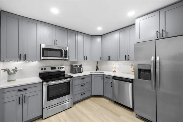 a kitchen with a sink stainless steel appliances and cabinets