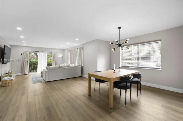 a living room with furniture a window and wooden floor