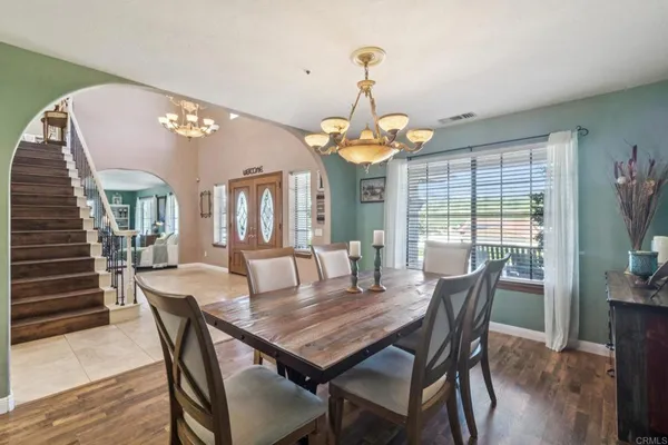 a view of a dining room with furniture wooden floor and chandelier