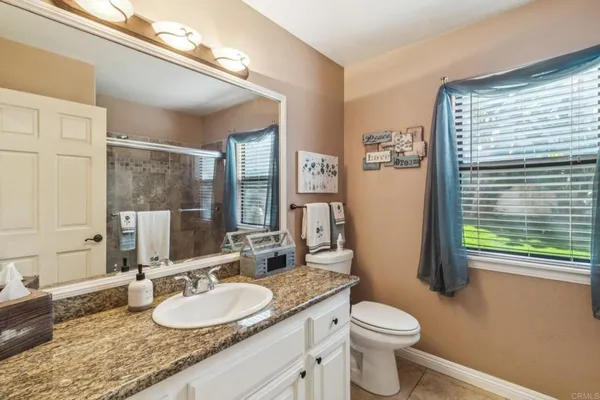 a room with stainless steel appliances kitchen island granite countertop a table chairs and a refrigerator