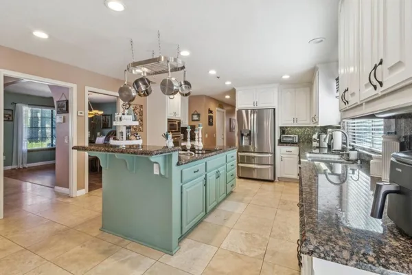 a kitchen with stainless steel appliances granite countertop a sink and a refrigerator