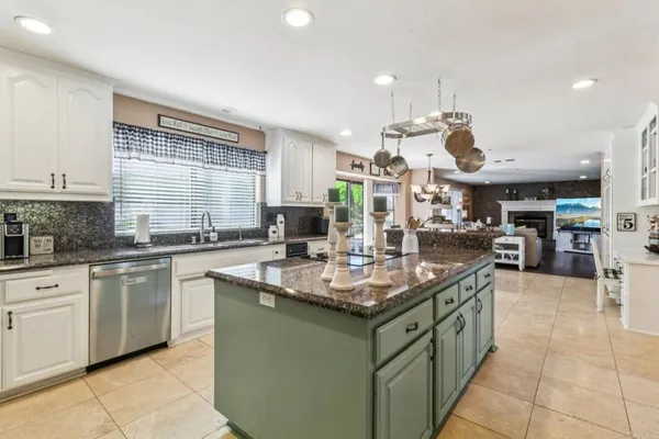 a kitchen with stainless steel appliances granite countertop a sink and a white cabinets