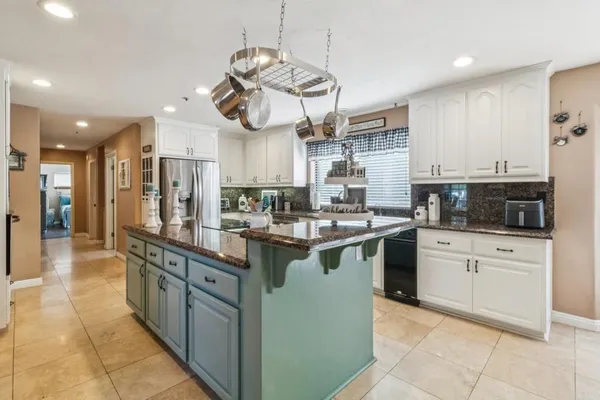 a kitchen with stainless steel appliances granite countertop a sink a stove and cabinets