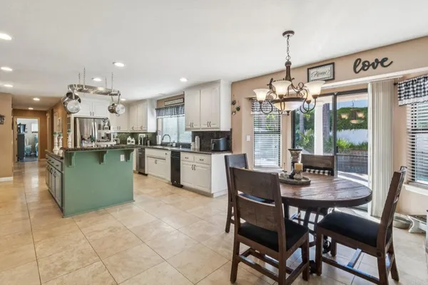 a view of a dining room and livingroom with furniture wooden floor a chandelier