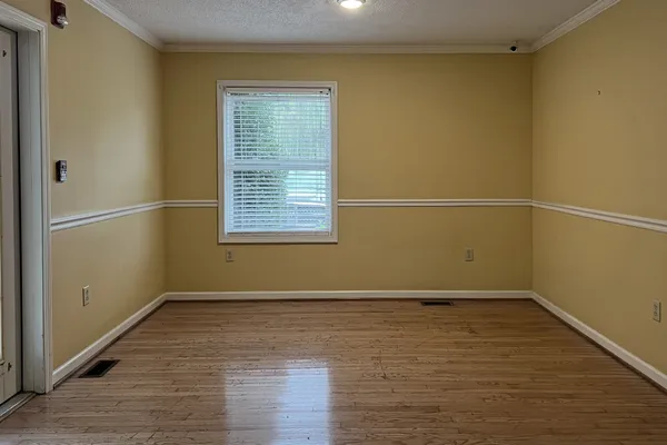 a view of a room with wooden floor and windows