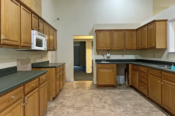 a kitchen with kitchen island granite countertop a sink stove and cabinets