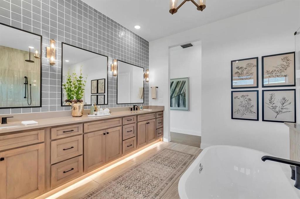 225 Bee Balm Road McKinney, TX 75071 - Photo 12 of 30 a spacious bathroom with a granite countertop sink a mirror a vanity and a bathtub
