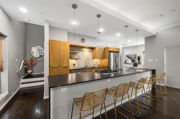 a kitchen with stainless steel appliances granite countertop a sink and a refrigerator