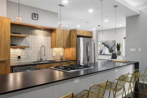 a kitchen with stainless steel appliances granite countertop a stove a sink and a refrigerator