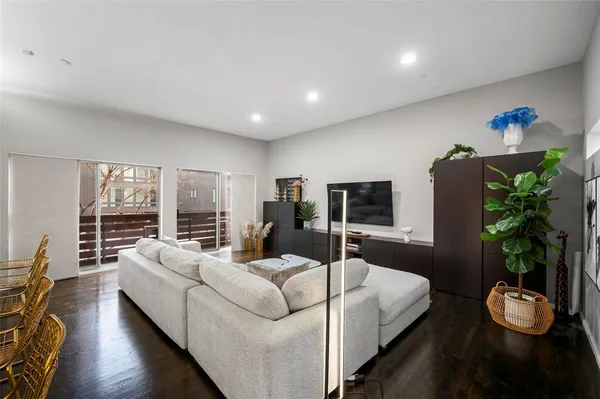 a living room with furniture potted plant and a flat screen tv