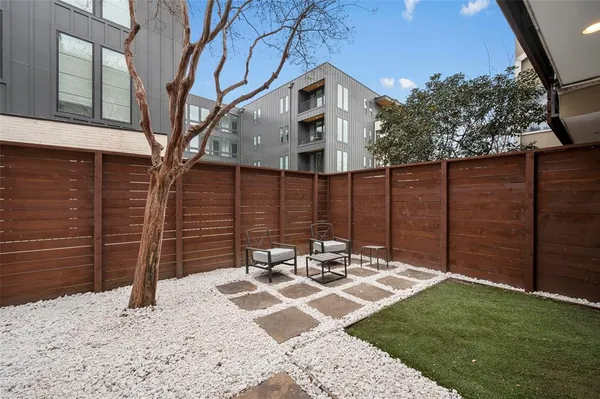 a view of a patio with table and chairs with wooden fence and plants
