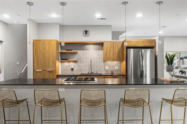 a kitchen with stainless steel appliances granite countertop a sink and a refrigerator