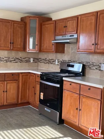 a kitchen with granite countertop cabinets stainless steel appliances and a counter space