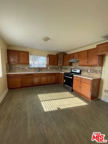 a large kitchen with stainless steel appliances granite countertop a stove a sink dishwasher and a refrigerator