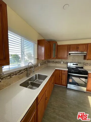 a kitchen with stainless steel appliances sink stove and cabinets