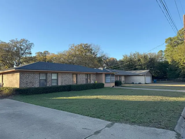 a front view of a house with a yard and trees