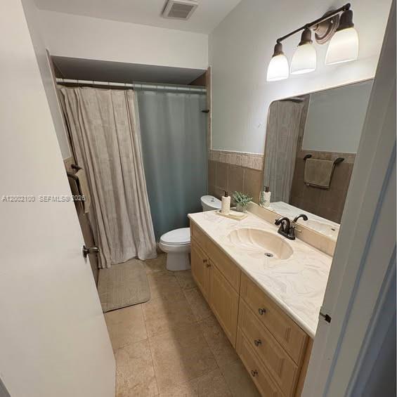 8650 Southwest 149th Avenue, Unit 310 Miami, FL 33193 - Photo 12 of 16 a bathroom with a sink a toilet a mirror and shower curtain