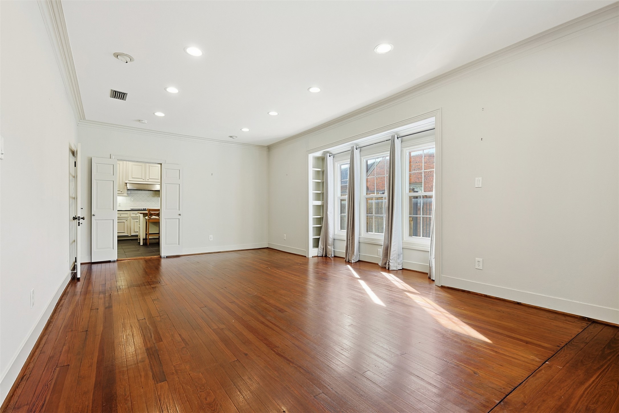 1311 Peden Street Houston, TX 77006 - Photo 2 of 21 an empty room with wooden floor and windows