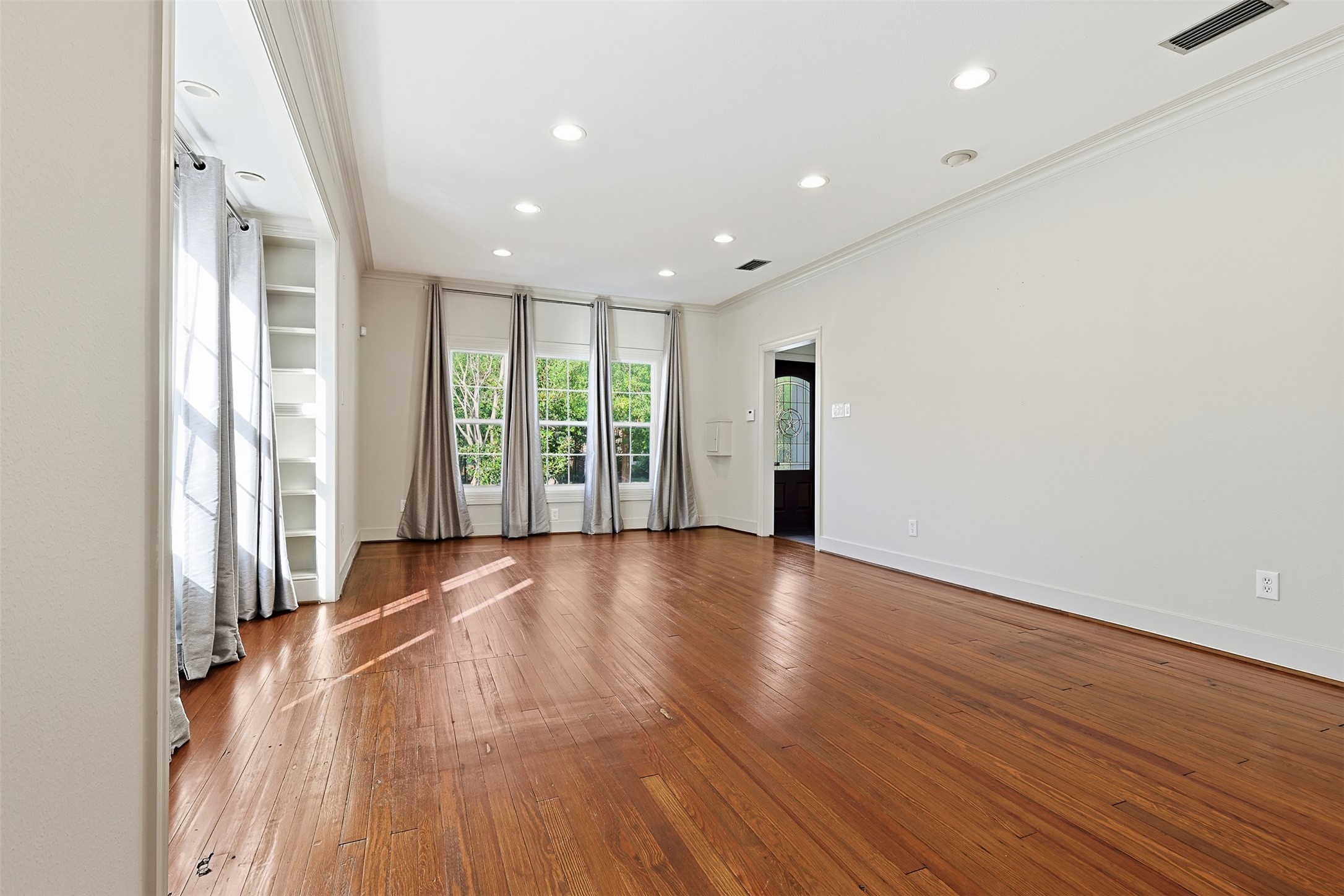 1311 Peden Street Houston, TX 77006 - Photo 3 of 21 an empty room with wooden floor and windows