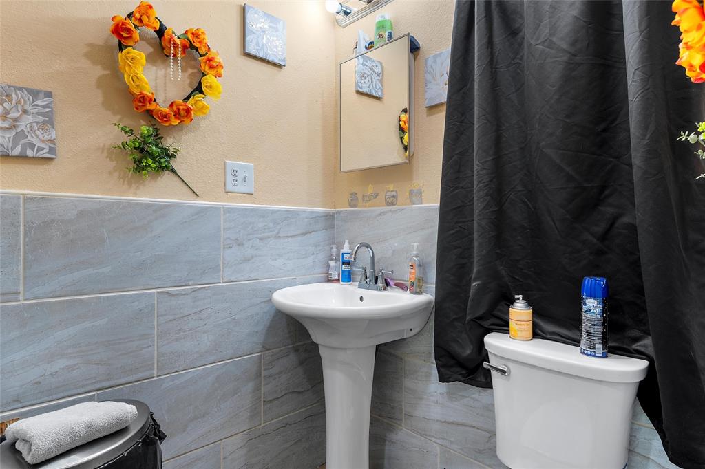 416 Capps Street Marlin, TX 76661 - Photo 11 of 25 a bathroom with a sink mirror and toilet