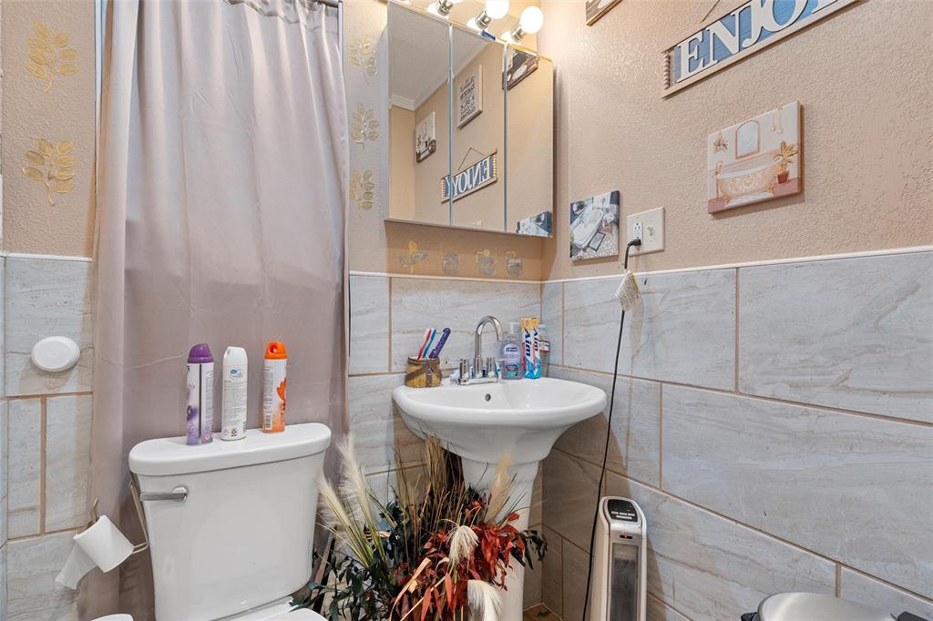 416 Capps Street Marlin, TX 76661 - Photo 13 of 25 a bathroom with a sink mirror and toilet