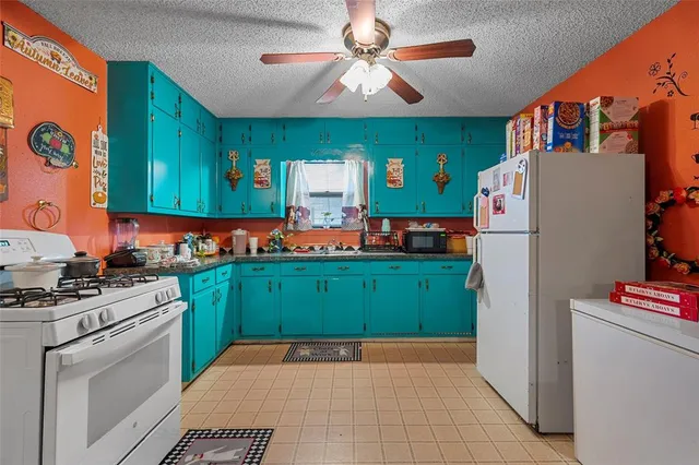 a kitchen with a refrigerator and a stove top oven