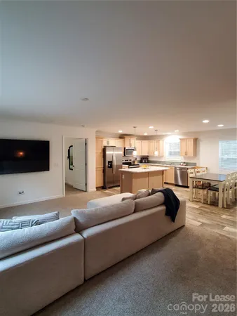 a living room with furniture and a view of kitchen