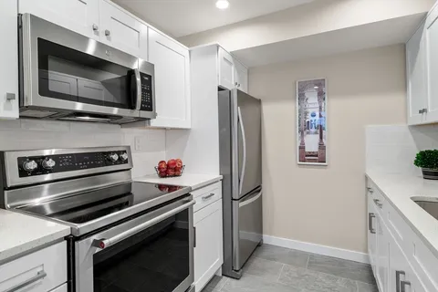 a kitchen with a refrigerator stainless steel appliances and cabinets