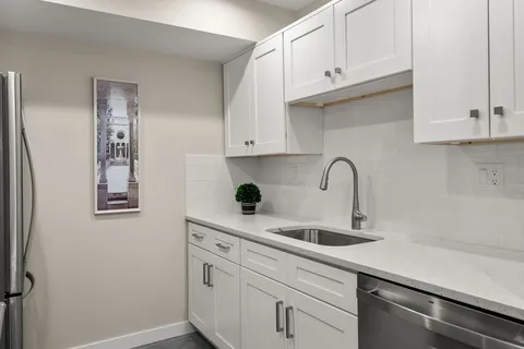 a kitchen with stainless steel appliances granite countertop a sink and a white cabinets