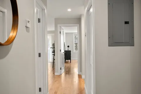 a view of a hallway with wooden floor and glass door