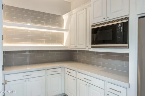 a kitchen with granite countertop white cabinets and a white stove