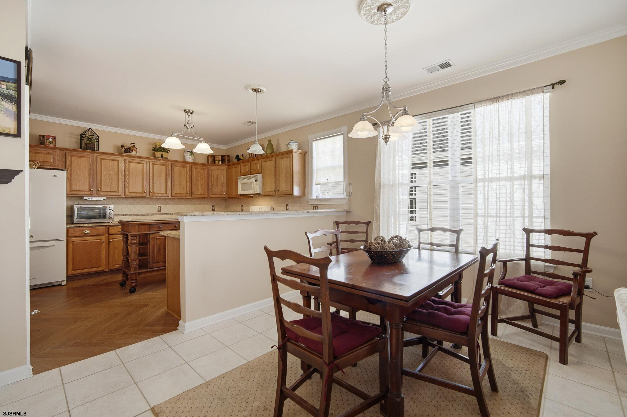 102 Warwick Road Galloway Township, NJ 08205 - Photo 12 of 45 a kitchen with stainless steel appliances kitchen island granite countertop a table chairs and a refrigerator