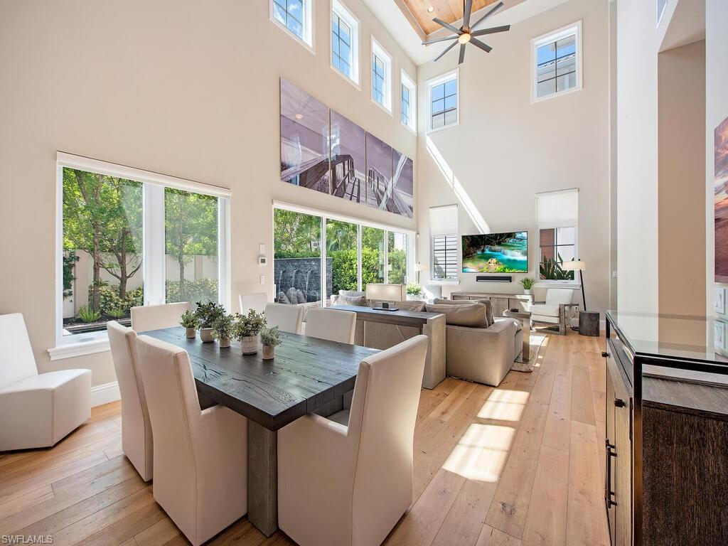 9200 Mercato Way Naples, FL 34108 - Photo 5 of 13 a dining room with furniture a rug and a floor to ceiling window