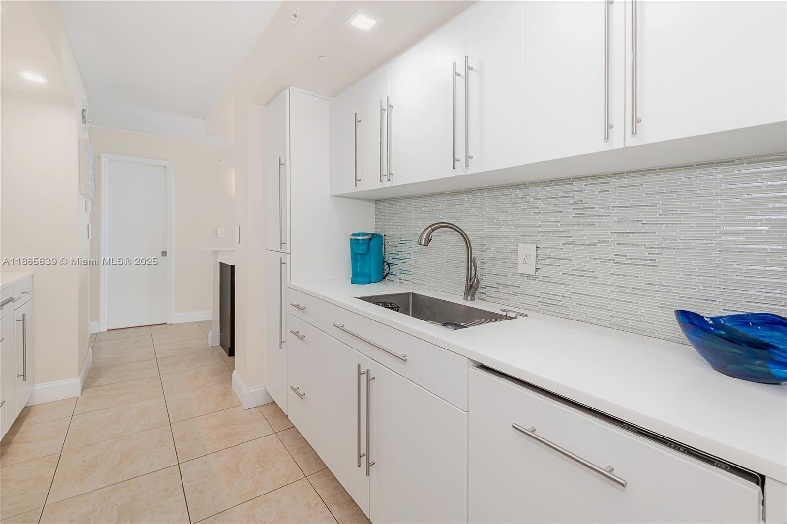 6917 Collins Avenue, Unit 511 Miami Beach, FL 33141 - Photo 11 of 24 a kitchen with a sink and cabinets