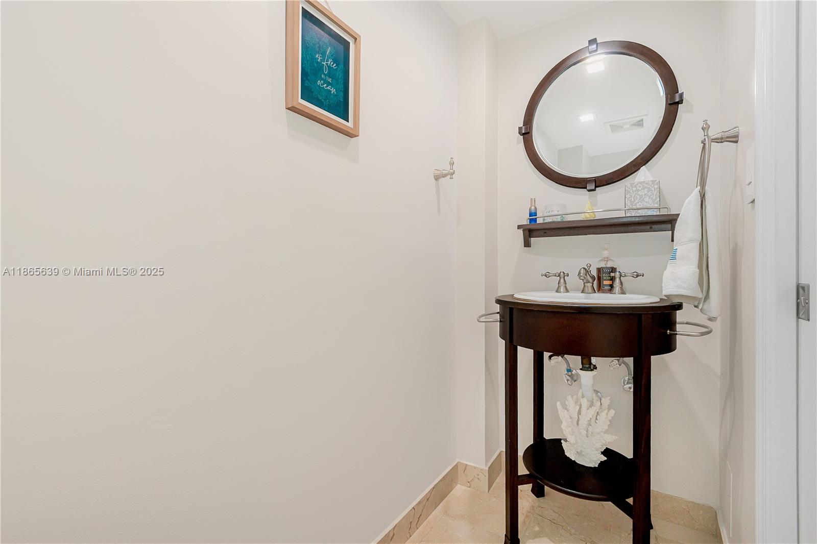 6917 Collins Avenue, Unit 511 Miami Beach, FL 33141 - Photo 13 of 24 a bathroom with a sink and a mirror