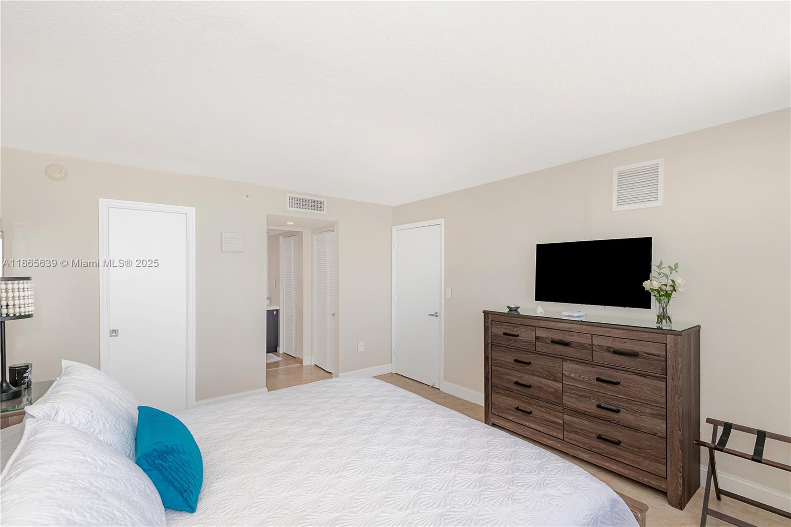 6917 Collins Avenue, Unit 511 Miami Beach, FL 33141 - Photo 21 of 24 a bedroom with a bed and a flat screen tv