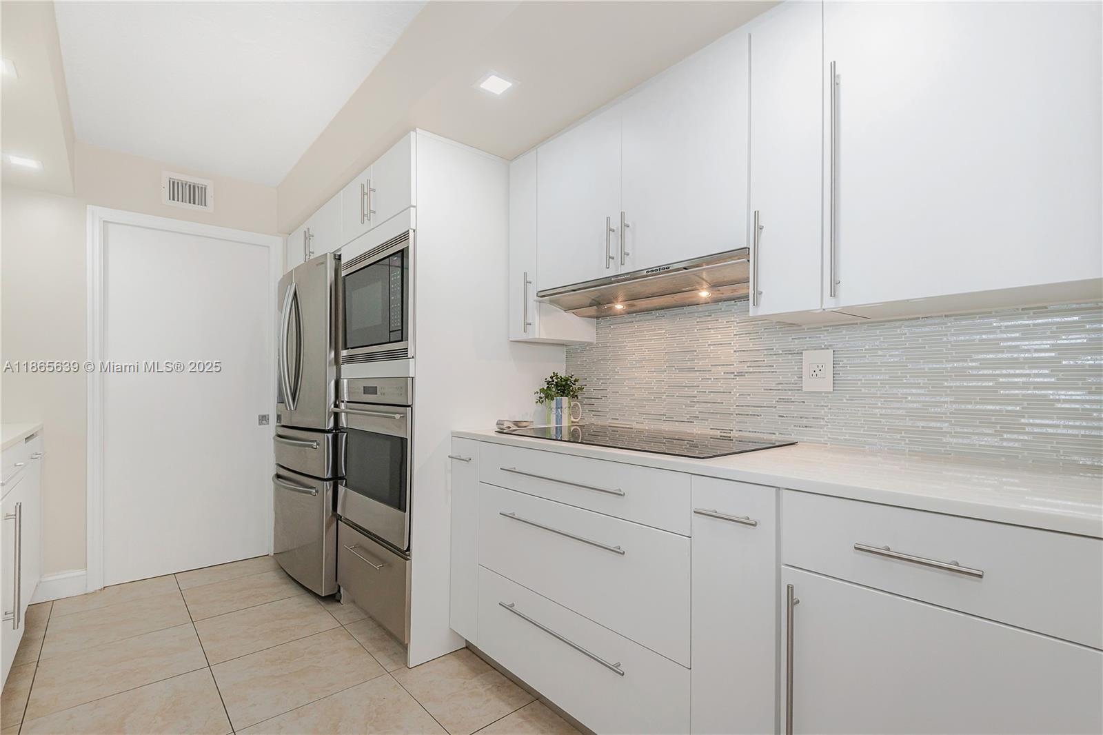 6917 Collins Avenue, Unit 511 Miami Beach, FL 33141 - Photo 8 of 24 a kitchen with stainless steel appliances a refrigerator and cabinets