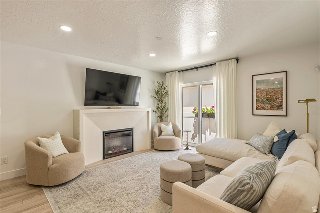 3916 South Sage Wood Avenue Mapleton, UT 84664 - Photo 1 of 33 Living space featuring a built-in electric fireplace with mantle, recessed lighting, and wood-finish flooring