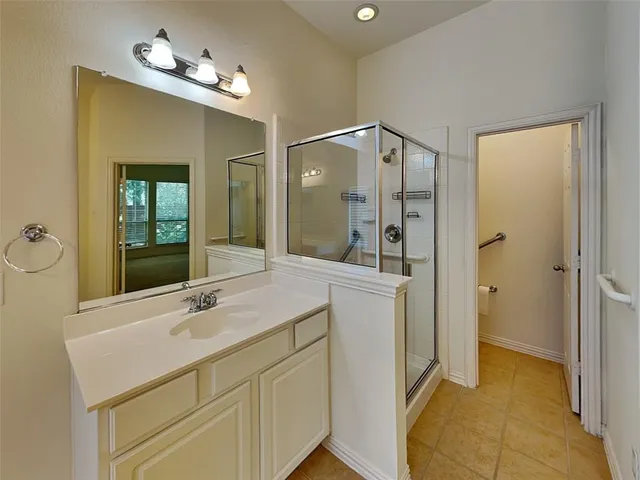 a bathroom with a double vanity sink mirror and shower