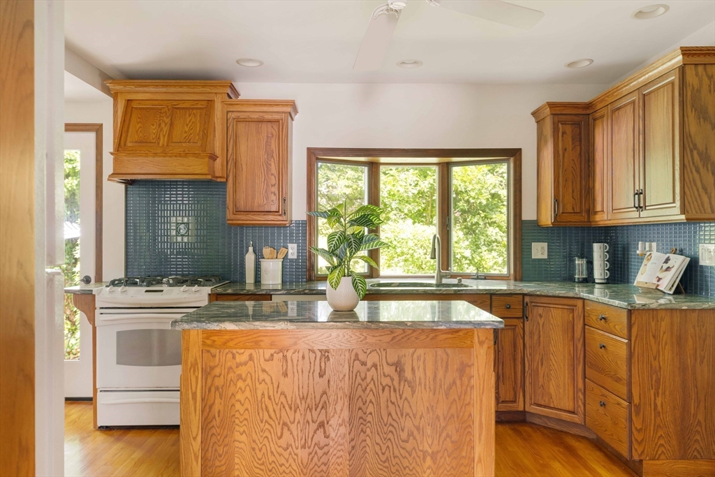 52 St Mary's Road Milton, MA 02186 - Photo 11 of 32 a kitchen with granite countertop a sink cabinets stainless steel appliances and a window