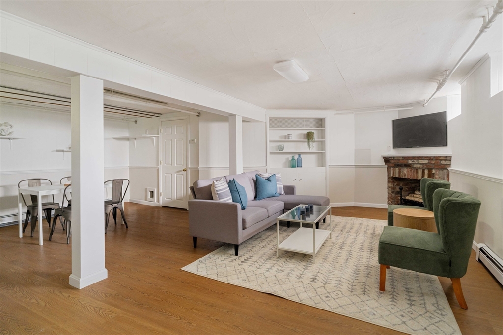 52 St Mary's Road Milton, MA 02186 - Photo 25 of 32 a living room with furniture a dining table and a flat screen tv